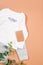 Set of warm baby clothes with bodysuits and tag on beige background. Collection of cute baby clothes. idea Gift for the birth of