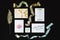 Set of wedding decorations: calligraphy, invitation cards, envelope, lace and ribbons on black background. Flat lay, close up. Rus