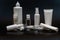 Set of white plastic bottles packages, tubes on black background. For cosmetic product