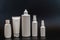 Set of white plastic bottles packages, tubes on black background. For cosmetic product. For cream, bottle with spray, lotio