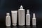 Set of white plastic bottles packages, tubes on black background. For cosmetic product. For cream, bottle with spray, oil, lotio