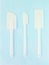 Set of white rubber spatula over blue background. Three pieces of silicone kitchen utensils
