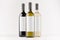 Set wine bottles - transparent, green, black- with blank white labels on white wooden board, mock up.