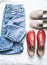 Set of women`s clothing for leisure, walks - mom`s jeans, suede beige slipons and red leather sport shoes with flat soles on a