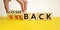 Setback or comeback symbol. Male hand flips wooden cubes and changes the word `setback` to `comeback`. Beautiful yellow and wh
