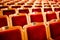 Sets on an empty theatre, taken with selective focus and shallow depth of field. Empty vintage red seats with numbers, teather cha