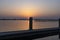 The setting sun almost disappears behind one of the bollards of a landing stage at Lake Zoetermeerse Plas in Zoetermeer, The Nethe