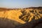 Setting sun on the eroded mountain ridges of desert dry and hot landscape at Zabriskie Point Death Valley National Park, USA