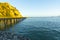 Setting sun illuminated cliffs and historic wharf at end of bay