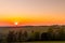 The setting sun over the forested mountain landscape of the Beskydy region, the sun sets beyond the horizon