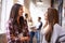 Settling in to college life. two female university students talking in the hallway with their friends in the background.