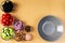 Seven bowls with tomatoes, black olives, cucumbers, colored peppers, pink salt, onion and walnuts