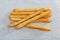 Seven bread sticks lying on a cotton tablecloth
