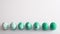 Seven Easter eggs with green pattern and gradient effect in row on white background
