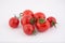 Seven fresh cherry tomatoes lie side by side isolated on white background.
