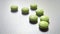 seven green antibiotic pill at white desk