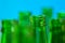 Seven green bottle necks on blue background