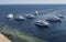 Seven moored diver`s yachts in the Red Sea, Egypt. White boats on a dark blue with gree sea look great for a travel agency or for