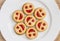 Seven round biscuits smiling faces on the white plate