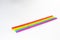 Seven straws of rainbow colors lie on a white background. Bright colors. The colors symbolize the concept of unification