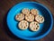 Seven sweet homemade cookies on a blue plate