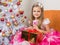 Seven-year girl in beautiful dress sits with a gift in their hands