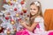 Seven-year girl in a beautiful dress treats Christmas toys and looked into the frame