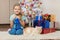 Seven-year girl sits with a cat under the Christmas tree with gifts and smiling happily