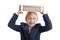 Seven-year-old blond boy in school uniform holds stack of notebooks on head. Portrait of primary school student is isolated on