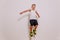 Seven-year-old boy in basketball uniform jumping high on white background