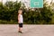 Seven-year-old boy in basketball uniform trains on an open basketball court in the summer. Kids and sports, boy in basketball