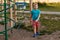Seven-year-old boy in a turquoise t-shirt and red shorts in the summer on the Playground