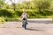 Seven-year-old boy in a white t-shirt rides a children`s blue bike outdoors in the summer