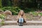 Seven year old girl communicates online on a smartphone, sitting in nature in the spring in the park