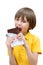 A seven years boy is biting a stick of chocolate