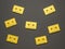 Seven yellow cassettes with magnetic tape on a black background. Flat lay