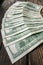 Several 100 dollar banknotes in semicircle layout on the aged rough wooden windowsill.