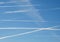 Several airplane contrails crossing the blue sky in a flyover state