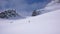 Several backcountry skiers hike and climb to a remote mountain peak in Switzerland on a beautiful winter day