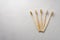 Several bamboo toothbrushes on a light concrete background. Top view with copy space.
