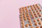 Several blisters with medicine pills on pink background. Rows of tablets, capsules
