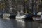 Several boats on the canal in Amsterdam in the sunlight