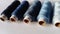 Several bobbins of thread in different shades of blue. Spools of thread located on a white background