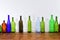 Several bottles on top of a wooden table with a white background