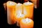 Several burning candles on a dark background