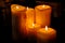 Several burning candles on a dark background