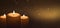 Several burning candles with festive bokeh on a dark gold background.