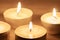 Several burning candles with wooden background macro
