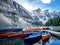 SEVERAL CANOES ON A DOCK ON LAKE MORAINE WITH MOUNTAIN BACKGROUND