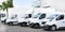 Several cars vans trucks parked in parking lot for rent